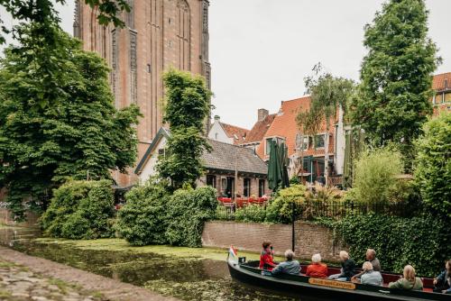 people riding on a boat down a river at Long John's Hotel in Amersfoort