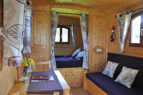 a bedroom with two beds in a log cabin at Roulotte Beaulieu in Saint-Jean-dʼAngle
