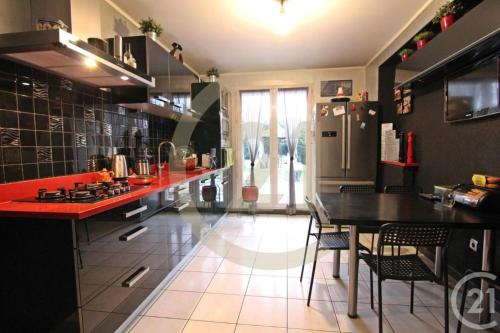 a kitchen with a black table and a refrigerator at Hello Disneyland Paris in Bussy-Saint-Georges