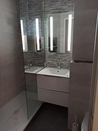 une salle de bain avec deux lavabos et un miroir dans l'établissement Les embruns, à Bormes-les-Mimosas