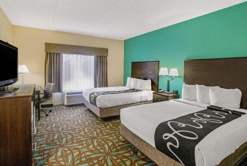 a hotel room with two beds and a flat screen tv at Comfort Inn & Suites Sarasota I75 in Sarasota