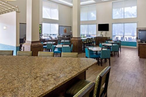 a dining room with tables and chairs and windows at Comfort Inn & Suites Sarasota I75 in Sarasota