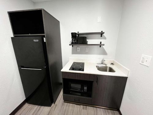 a small kitchen with a sink and a refrigerator at Studio 6 Lafayette, LA I-10 & I-49 N in Lafayette