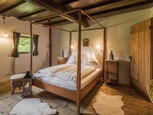 Chalet Wolfbachgut في تاكسنباخ: غرفة نوم مع سرير مظلة في غرفة