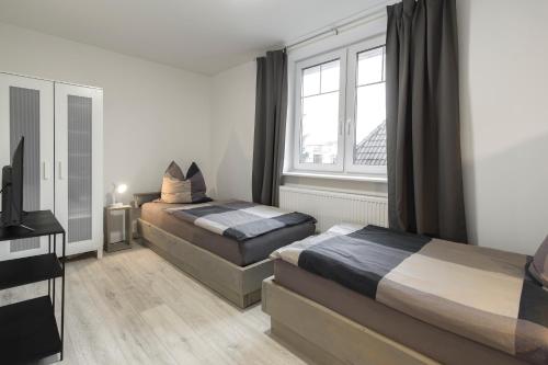 um quarto com 2 camas e uma janela em Arkadia Apartments-Schwissel-Bad Segeberg em Schwissel