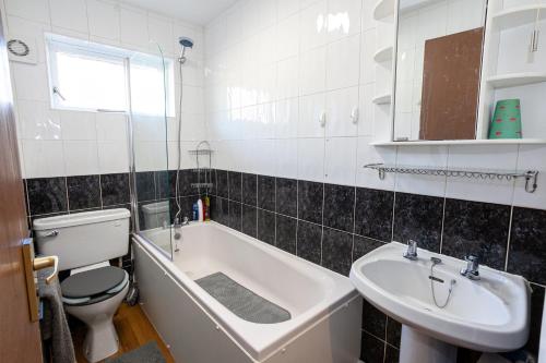 a bathroom with a tub and a toilet and a sink at Spacious House in Sheffield - Great Location! in Attercliffe