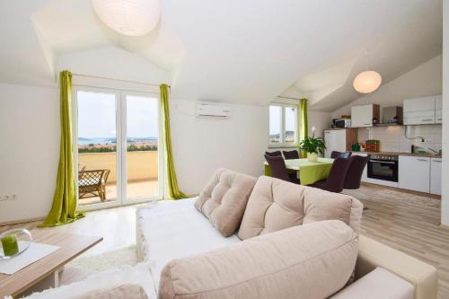 a living room with a white couch and a table at Apartments Marjanovic in Vodice