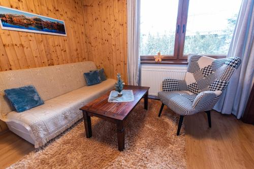 a living room with a couch and a table and a chair at Ubytovanie Pri zvonici, Dlhá 149 Liptovský Mikuláš in Liptovský Mikuláš