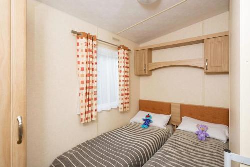 two beds in the corner of a room at Whitecliff Bay Holiday Park in Bembridge
