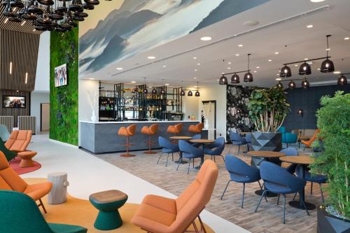 a lobby with tables and chairs and a bar at Citadines Eurometropole Strasbourg in Strasbourg