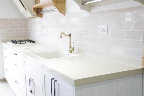a white kitchen with a sink and white tiles at נווה חרמון in Majdal Shams