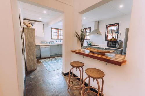 a kitchen with two stools and a counter in it at Miracle Mountain Cottage in Howick
