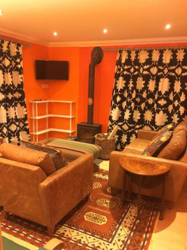 salon z kanapami i piecem opalanym drewnem w obiekcie Charming 3-Bed House in Abergele Wales UK w mieście Abergele
