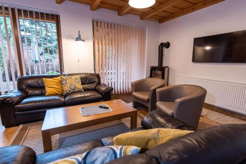 a living room with leather furniture and a tv at Ubytovanie Pri zvonici, Dlhá 149 Liptovský Mikuláš in Liptovský Mikuláš