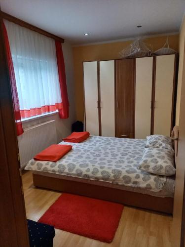 Schlafzimmer mit einem Bett und einem Fenster in der Unterkunft Apartman Ivano in Kupres