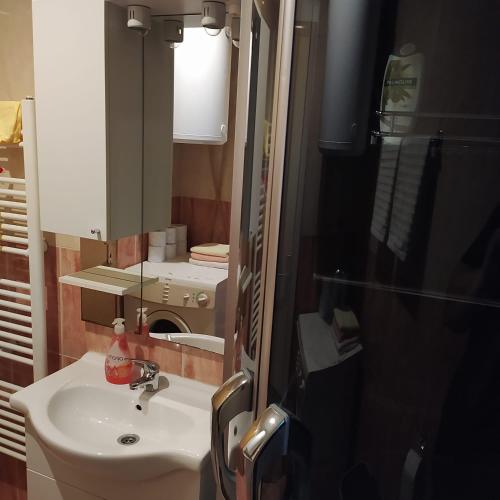 ein Badezimmer mit einem weißen Waschbecken und einem Spiegel in der Unterkunft Apartman Ivano in Kupres