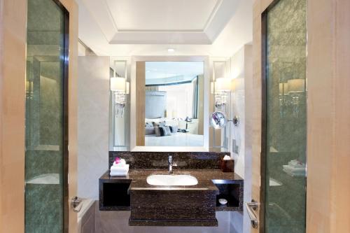 a bathroom with a sink and a mirror at Dorsett Grand Subang Hotel in Subang Jaya