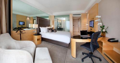 um quarto de hotel com uma cama e uma secretária com um computador em Dorsett Grand Subang Hotel em Subang Jaya