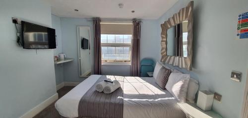 een slaapkamer met een bed, een spiegel en een televisie bij INNit Joy in Brighton & Hove