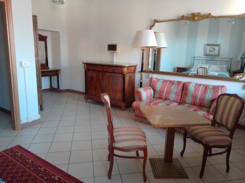 a living room with a couch and a table and chairs at Albergo e Ostello della gioventù Biella centro storico in Biella