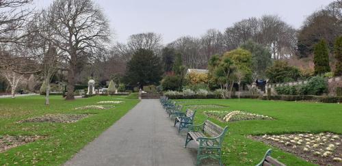 a row of benches sitting in a park at Tivoli Bungalow in Weston-super-Mare