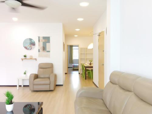 a living room with a couch and a chair at Eden 8pax 3Rooms apartment near Kuching Airport in Kuching
