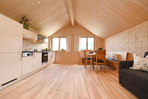 a kitchen and living room with a couch and a table at Ferienhof Landerleben in Egg