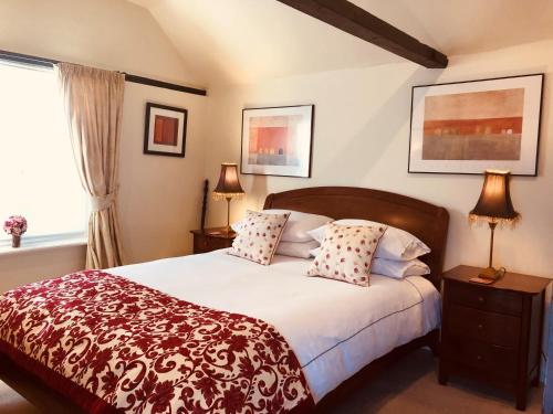 a bedroom with a bed and two lamps and a window at The Blue Cow in Fenstanton