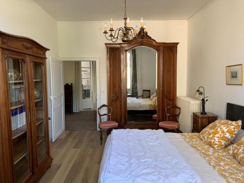 une chambre avec un lit et un grand miroir dans l'établissement Grand corps de ferme à la rue Messire Etienne 89113 Neuilly Valravillon, à Neuilly