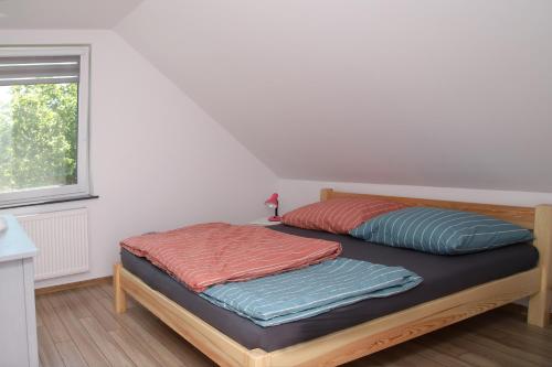un letto con due cuscini sopra in una stanza di Bolek Lolek Domki Apartamenty a Wilkasy