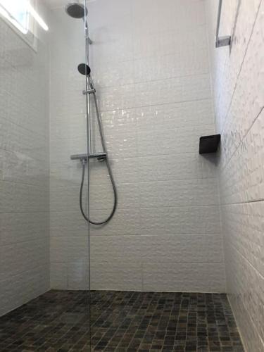 une douche avec une porte vitrée dans une salle de bain dans l'établissement Maison St Clair vue mer, à Sète