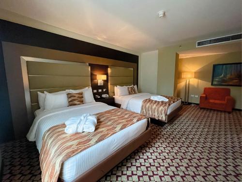 a hotel room with two beds and a chair at Waldorf Hotel in Caracas