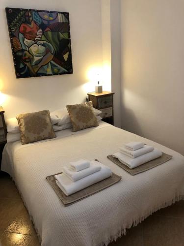 a bedroom with a bed with two towels on it at Torrox Pueblo Hidden Gem, 2 Bed Apartment in Torrox