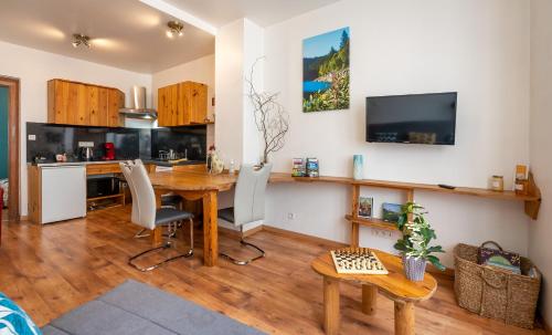 a living room with a wooden table and a kitchen at Gîtes Schwendi - Quartier Petite Venise in Colmar