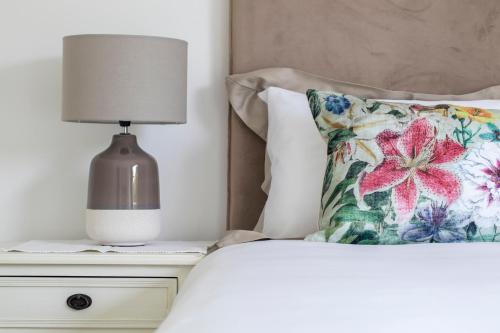a bed with a pillow and a lamp on a night stand at Birdsong in Hermanus