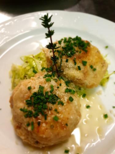 two pieces of food on a white plate with broccoli at Hotel Rose in Villabassa