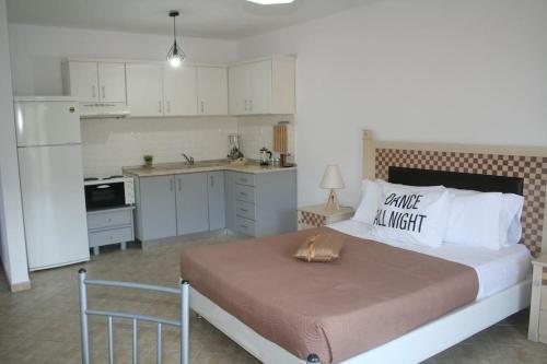 a bedroom with a large bed and a kitchen at Moschoula Villa - Apartment 1 in Limenas