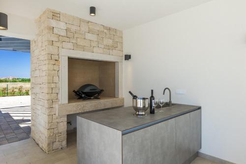 a kitchen with a stone fireplace in a house at Villa Bella by SeeAdria Agency in Brtonigla