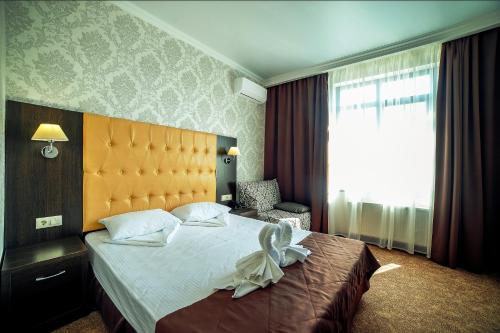 ゲレンジークにあるБутик-отель Астерияの大きなベッドと窓が備わるホテルルームです。