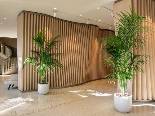 two palm trees in a lobby with a wall at ME Milan Il Duca in Milan