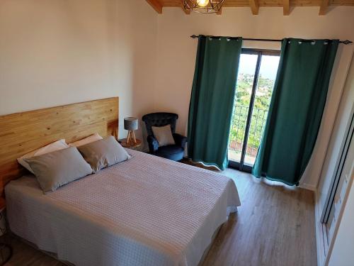 a bedroom with a bed with green curtains and a window at Ponta do Sol Private Apartment Sea View in Ponta do Sol