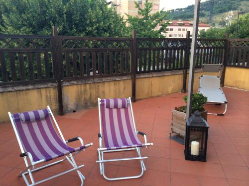 two chairs sitting on a patio with a fence at La Terrazza in Spoleto