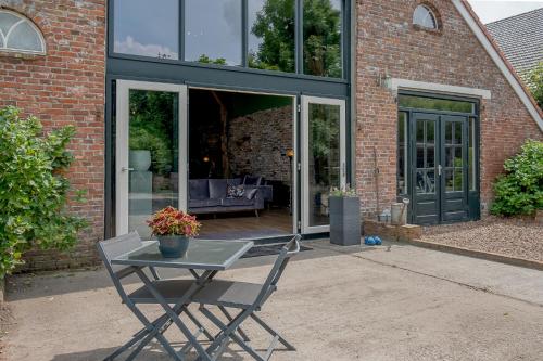 a table and a chair in front of a building at Boeren Maison in Wedde