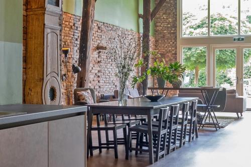 a restaurant with tables and chairs and a brick wall at Boeren Maison in Wedde