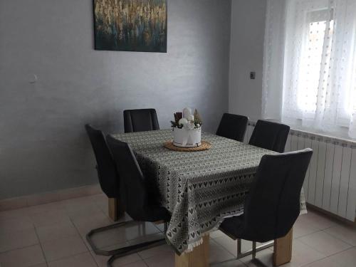 a dining room table with black chairs and a cake on it at Apartment Roki in Zagreb