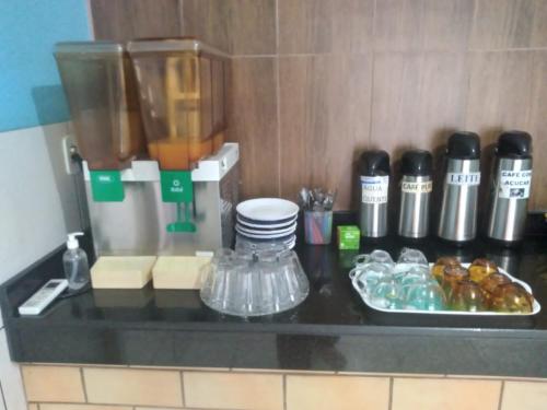 a counter top with a coffee maker and some food at Hotel Kolosso in Aragarças