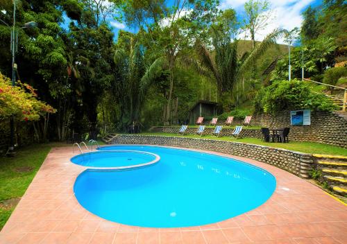 a large blue swimming pool in a yard at Fundo San Jose Parque Ecológico & Lodge Hotel Asociado Casa Andina in La Merced