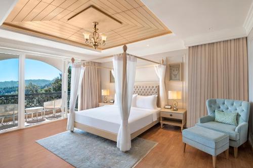 a bedroom with a bed and a chair and a window at Welcomhotel by ITC Hotels, Tavleen, Chail in Chail