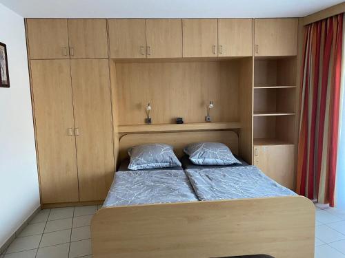 1 dormitorio con 1 cama y armarios de madera en Appartement Am Sonnenhang Erdgeschoss, en Bad Rothenfelde