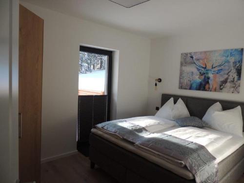 a bedroom with a large bed with a window at MountainLodge am Ötscher in Lackenhof